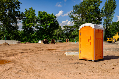 orange porta potty at a new construction site